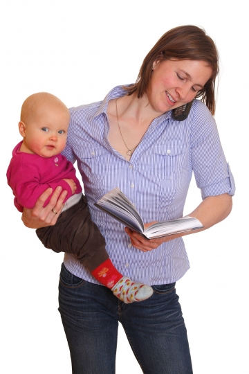 Woman holding baby and reading
