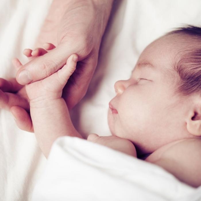 newborn holding a hand