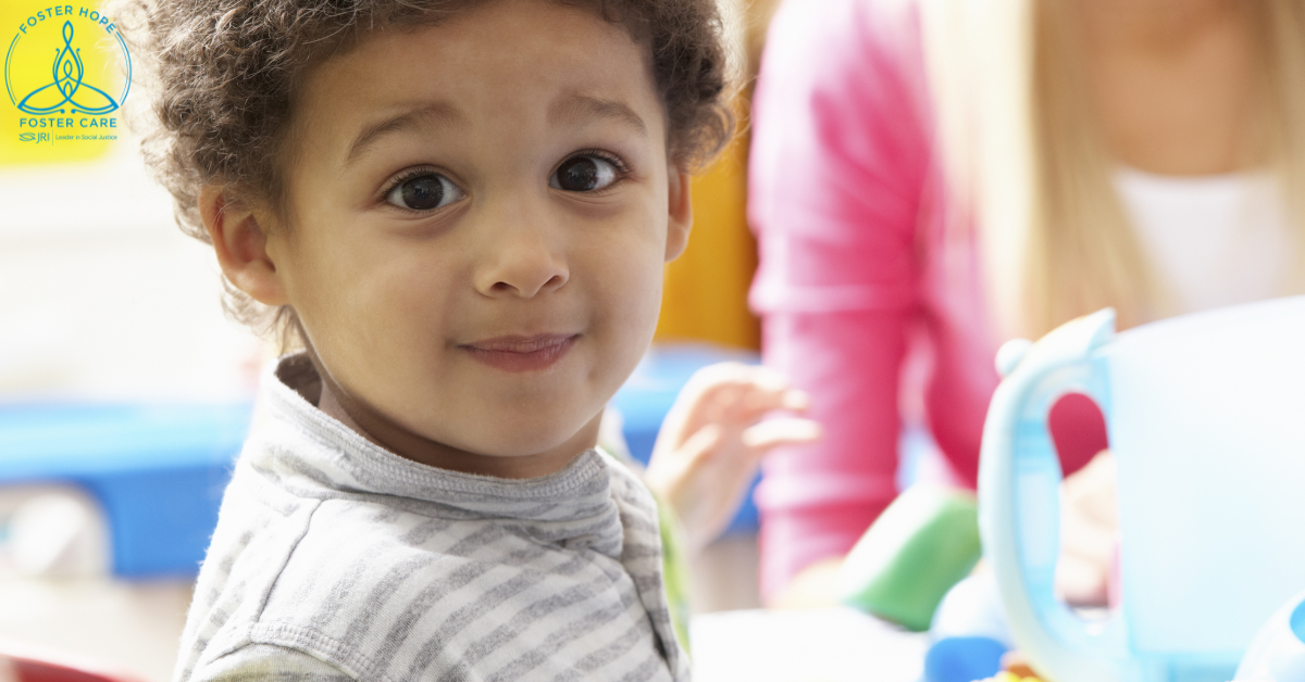 A little boy smiles softly at the camera.