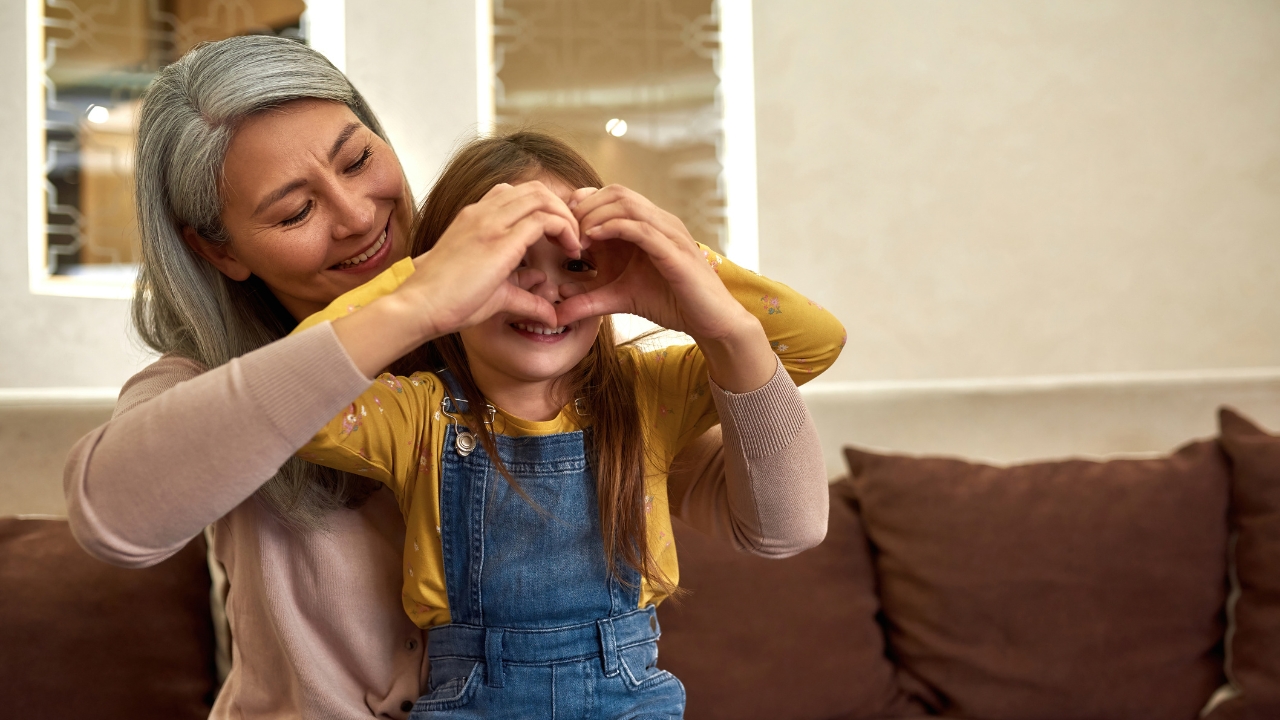 Foster parents with kid making a heart with hands