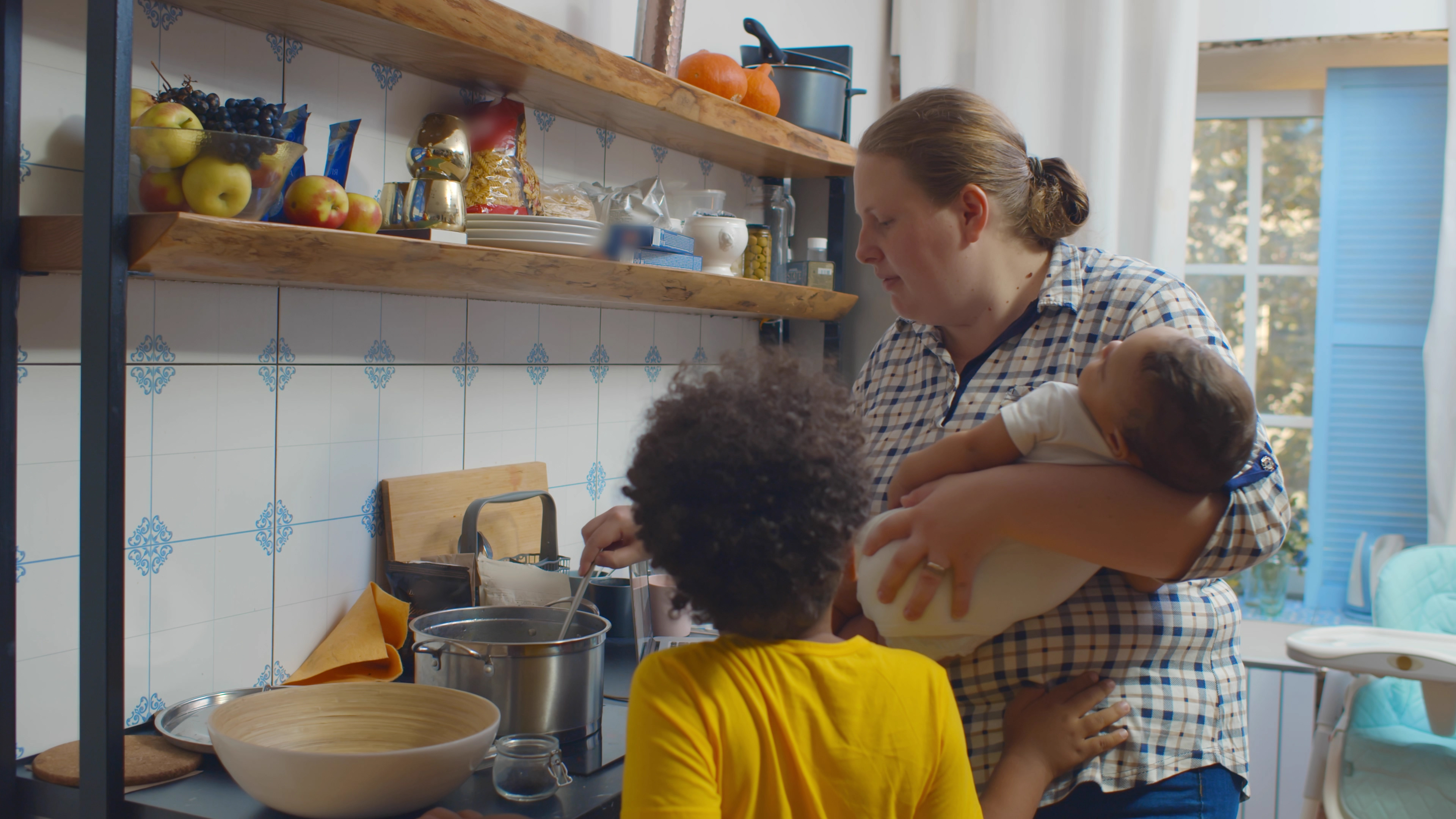 Foster Mother Stirring a Pot while holding a baby