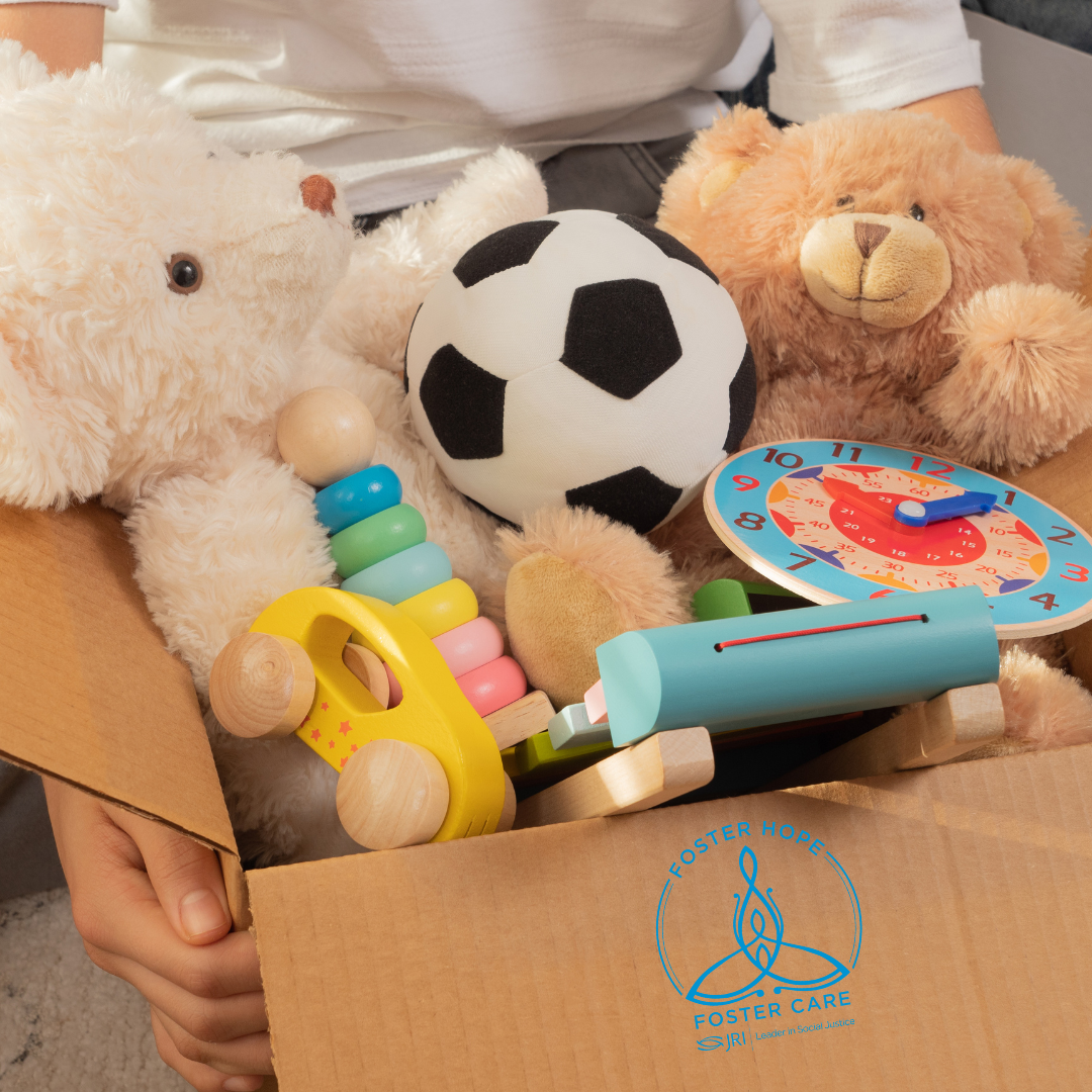 Child holds box of toys for donation.