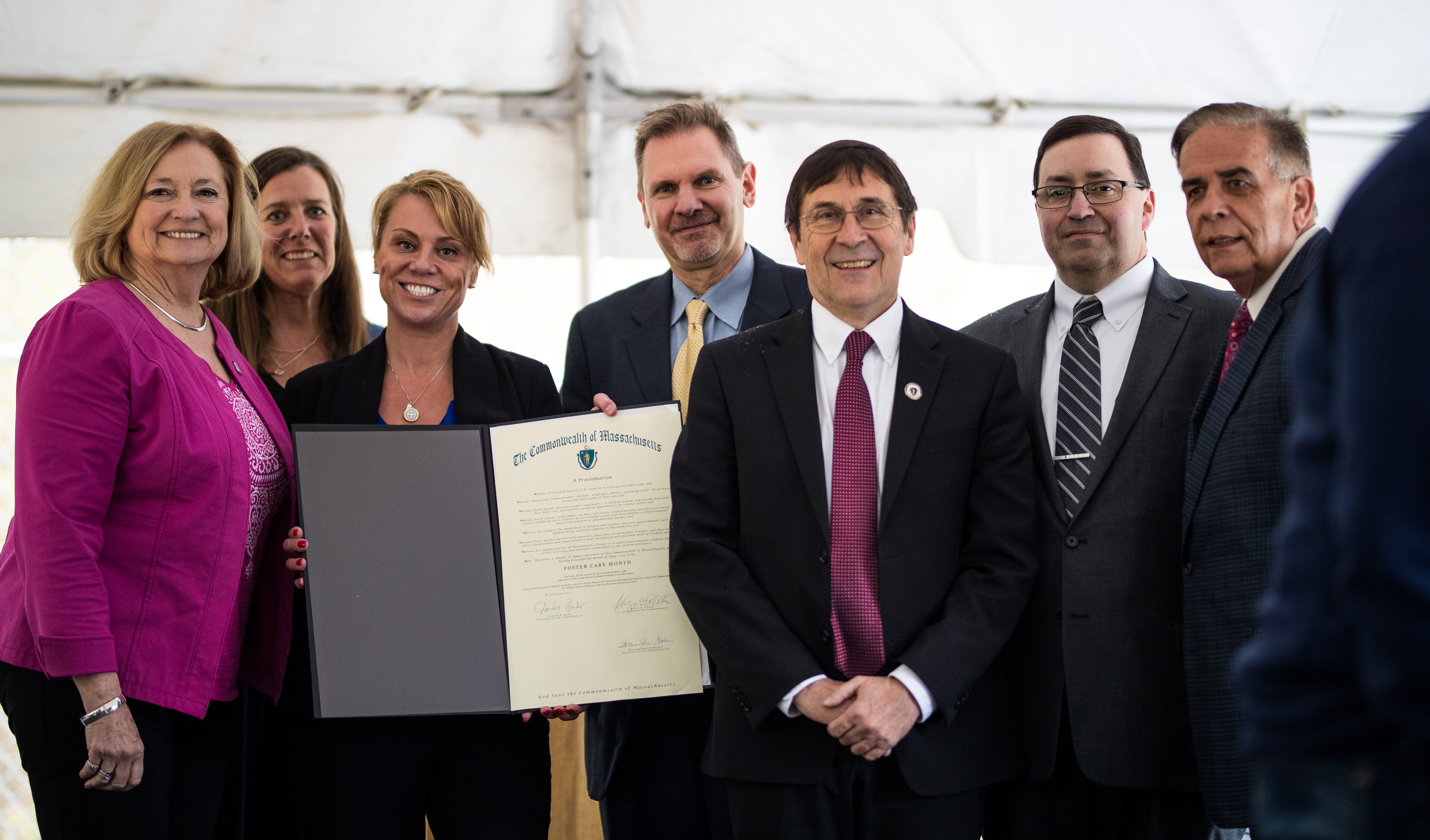 A group of JRI employees and legislatures pose for a group photo with the proclamation