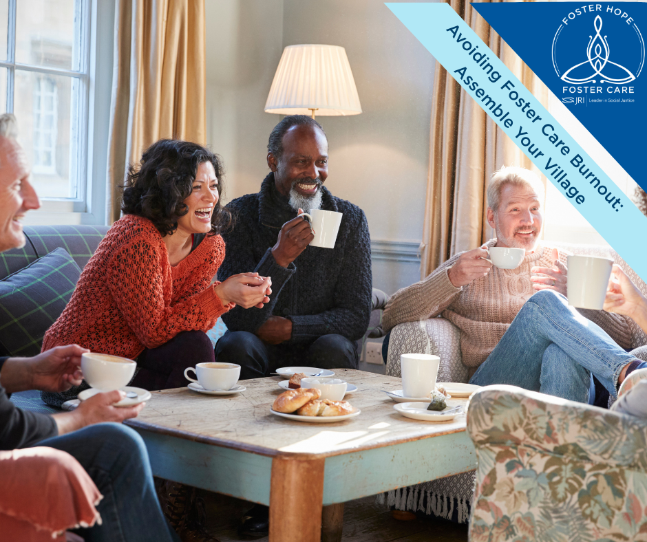 A group of four middle aged adults sit casually in a living room.  They are sipping coffee, laughing, and talking.