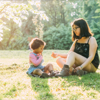 hispanic mother and child in a park on a sunny day