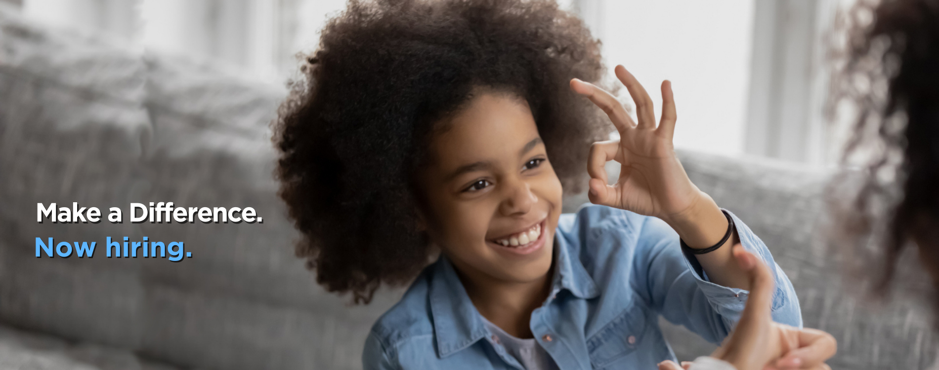 Young Black child giving the ok sign with text that says Make a Difference Now Hiring
