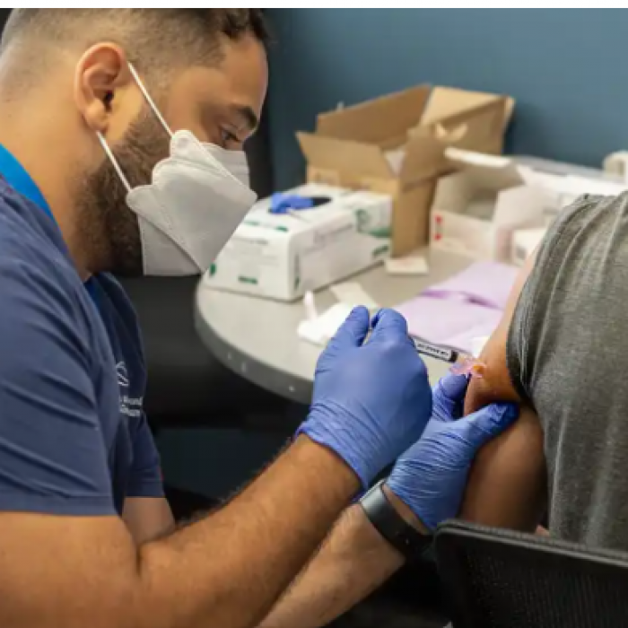 two males, one receiving a vaccination