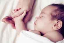 newborn holding a hand