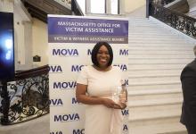 Jenese Brownhill holding the MOVA Victim Rights Award at the State House.