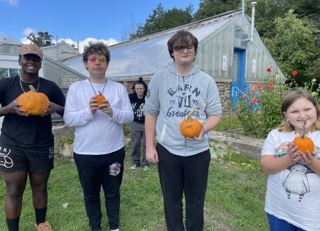 Four youth with pumpkins