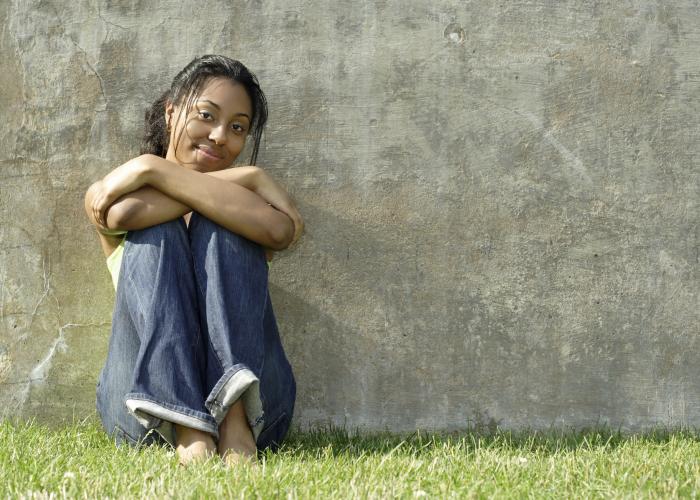 Girl sitting with back against wall