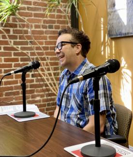 Adam Edwards sitting at a table in front of a microphone.