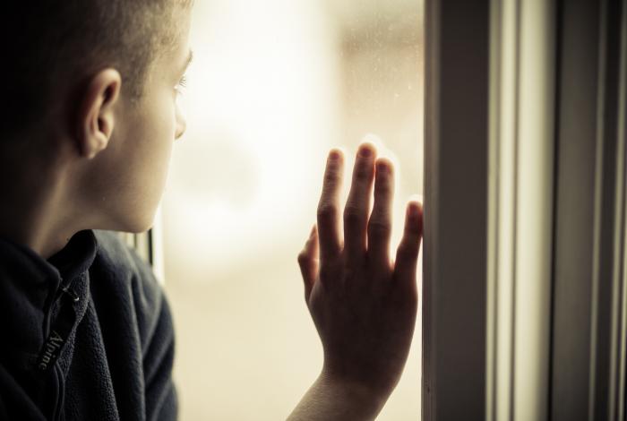 adolescent boy looking out window