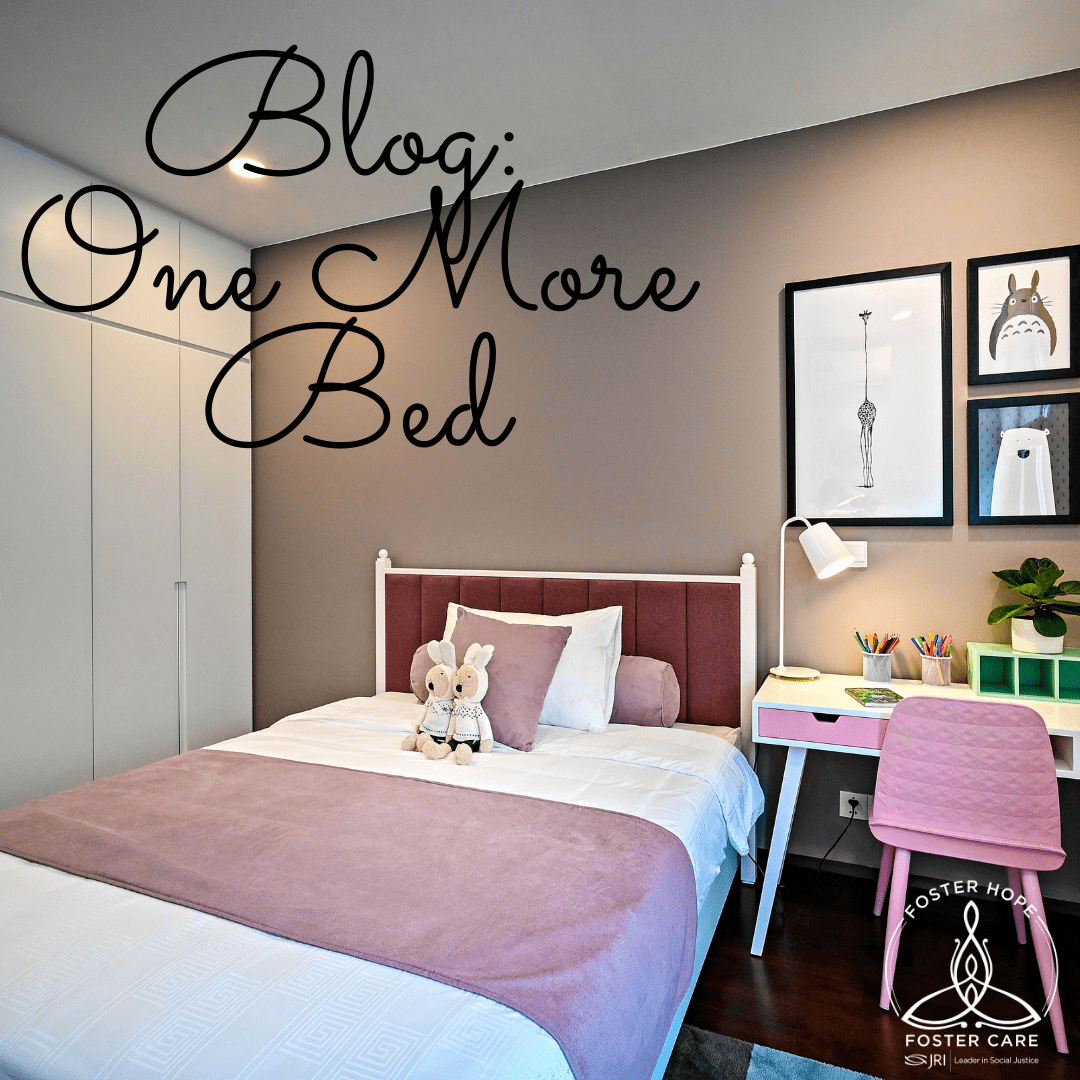 Image of a bedroom with a bed, stuffed animals, desk, and wall art.