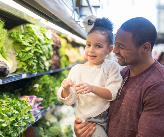 Adult holding a child in a grocery store,