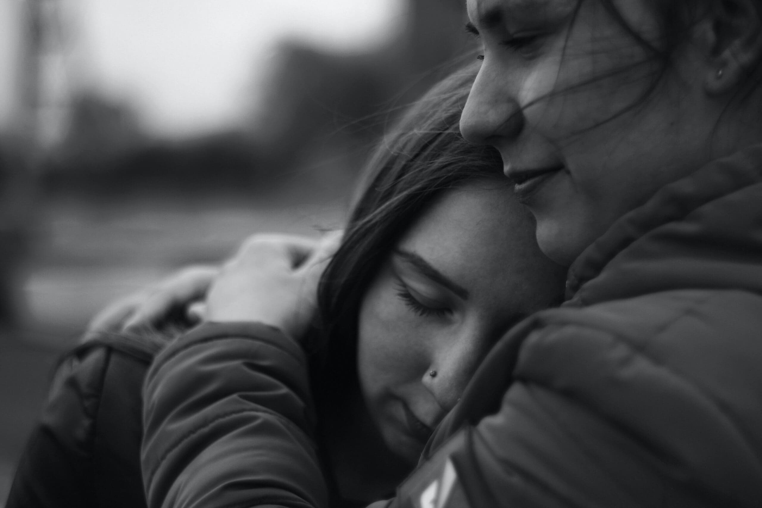 Two people embracing, one resting their head on the other's shoulder.
