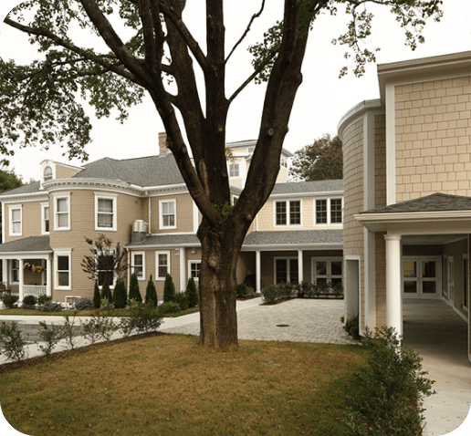 Large, multi-story building with trees and landscaped yard