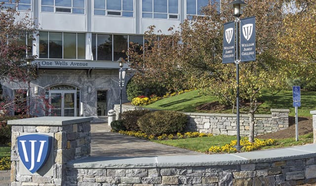 Campus building with William James College signs and entrance path.
