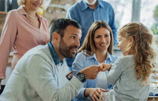 Group of four people interacting with a child in a supportive setting.