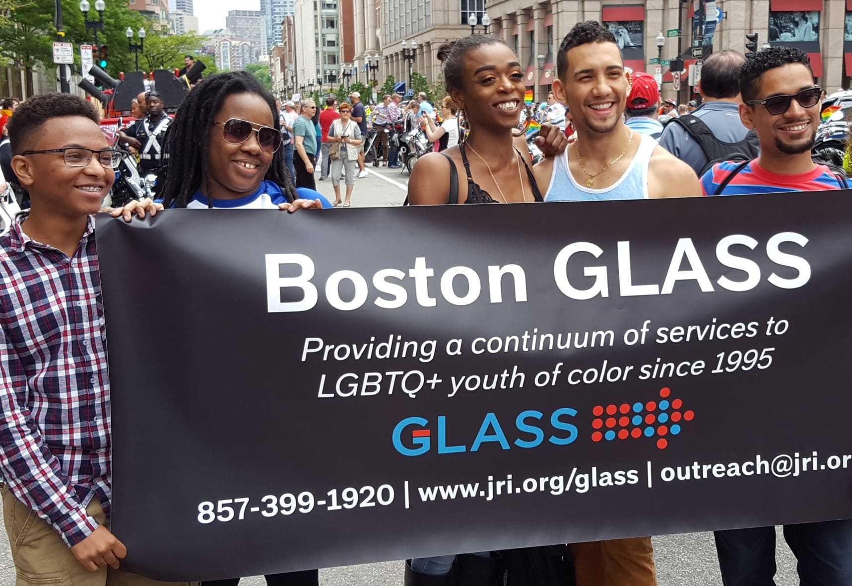 Group of people holding a GLASS banner at a pride parade.