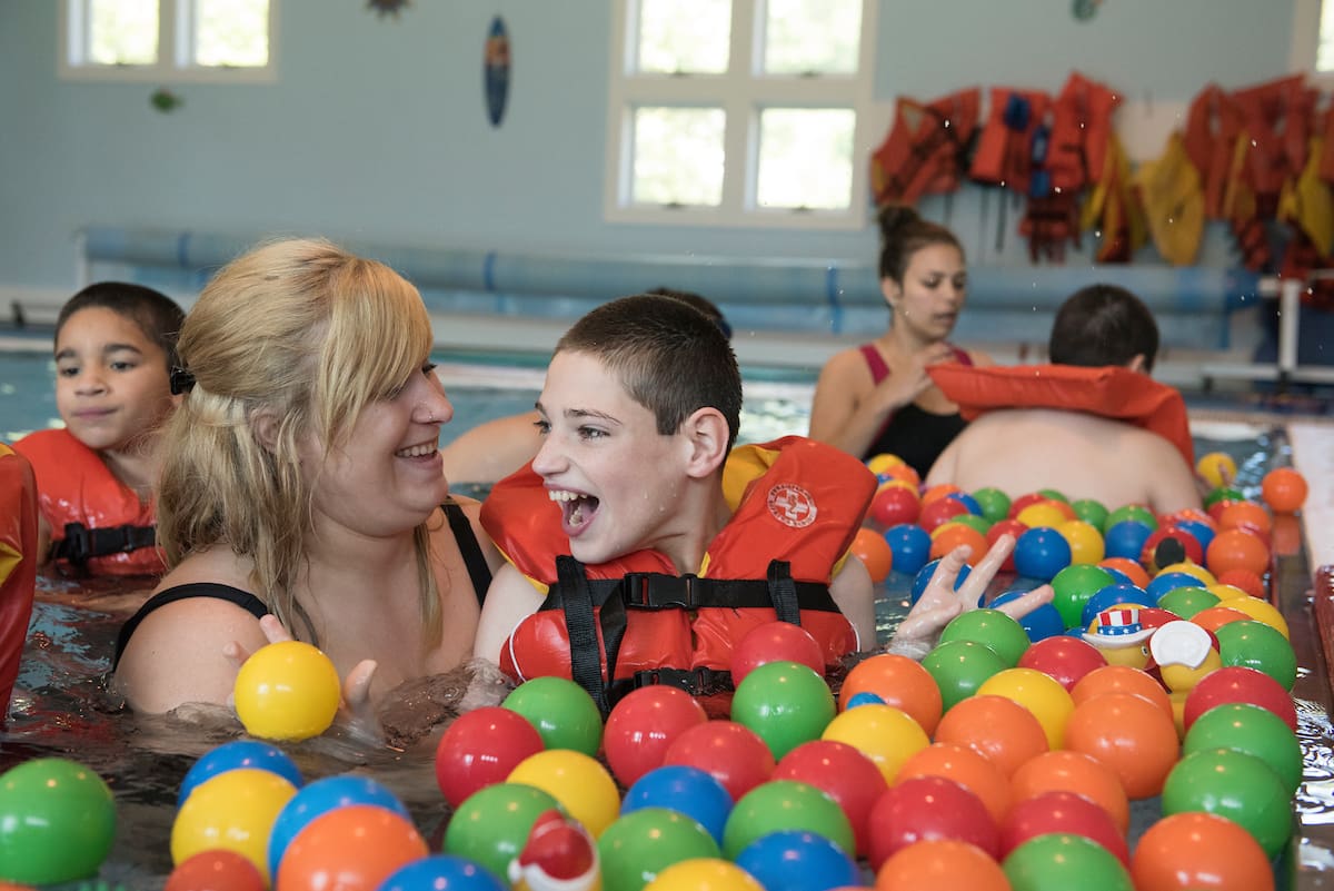 People in a swimming pool with colorful plastic balls.
