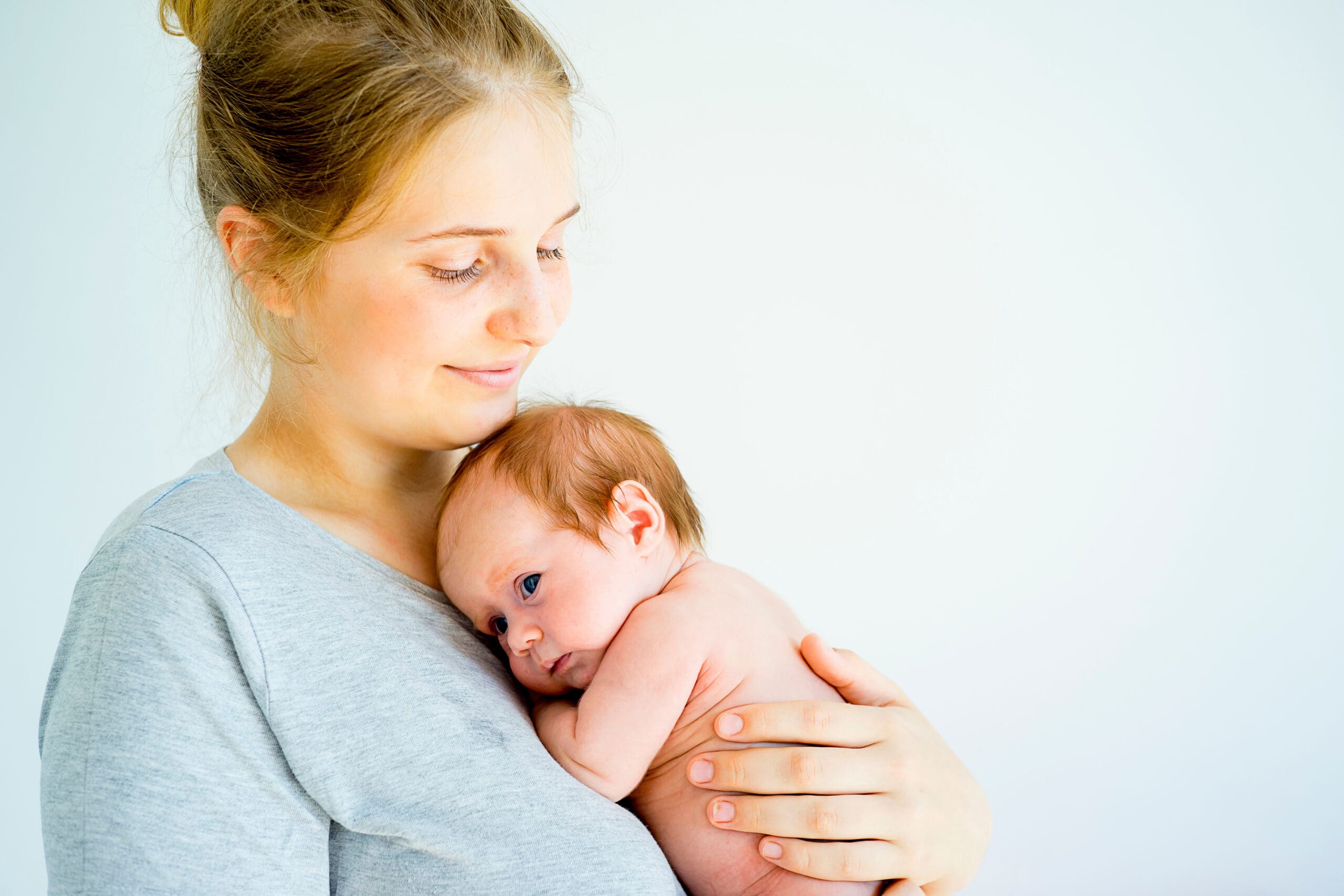 Young mother holding a baby and smiling