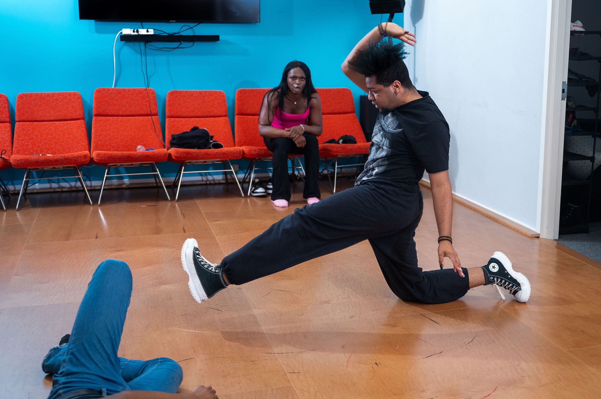 Person performing a dance move in a studio.