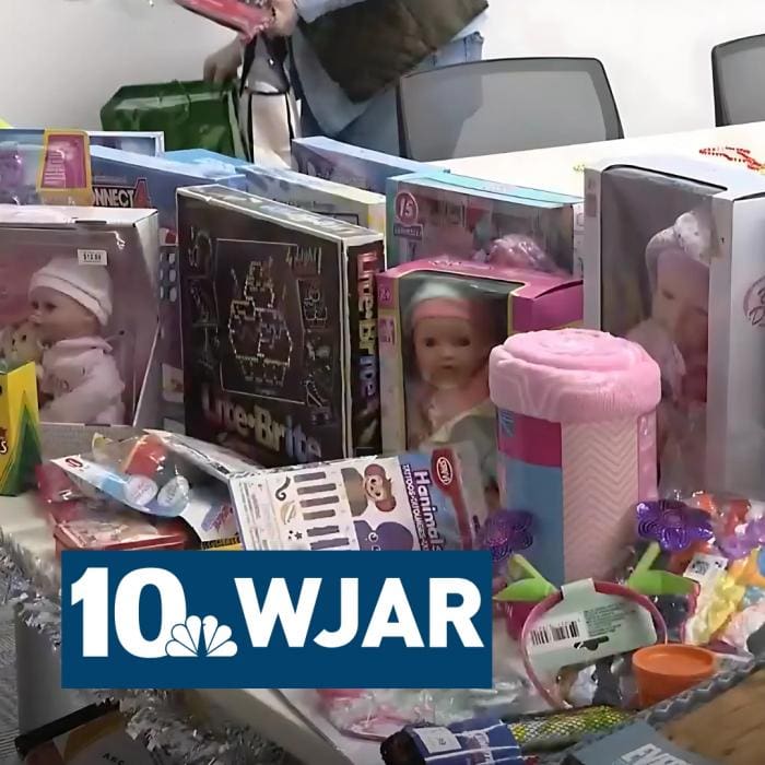 Table with toys and dolls, including baby dolls and a pink blanket.