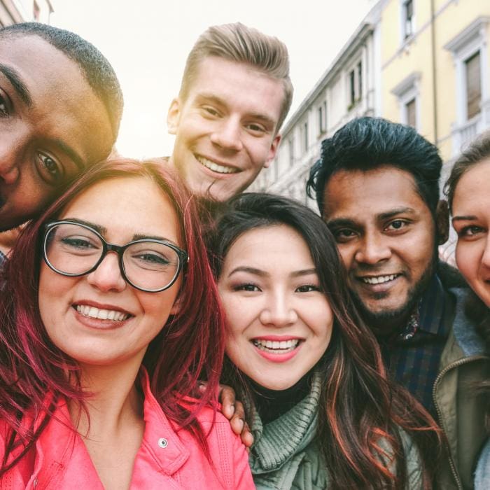 Group of smiling young people outdoors, close-up shot.