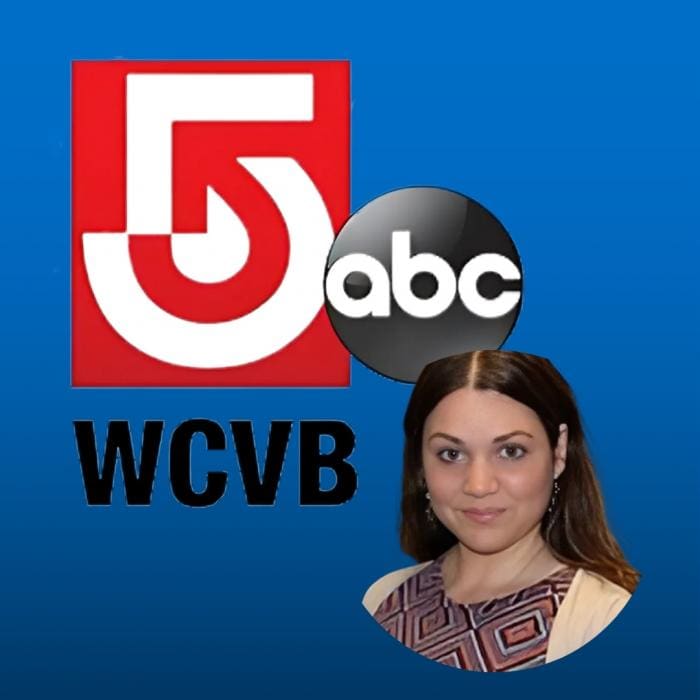 Woman with dark hair in front of TV station logos, blue background.