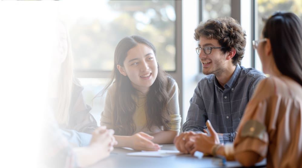 People sitting at a table, talking and smiling.