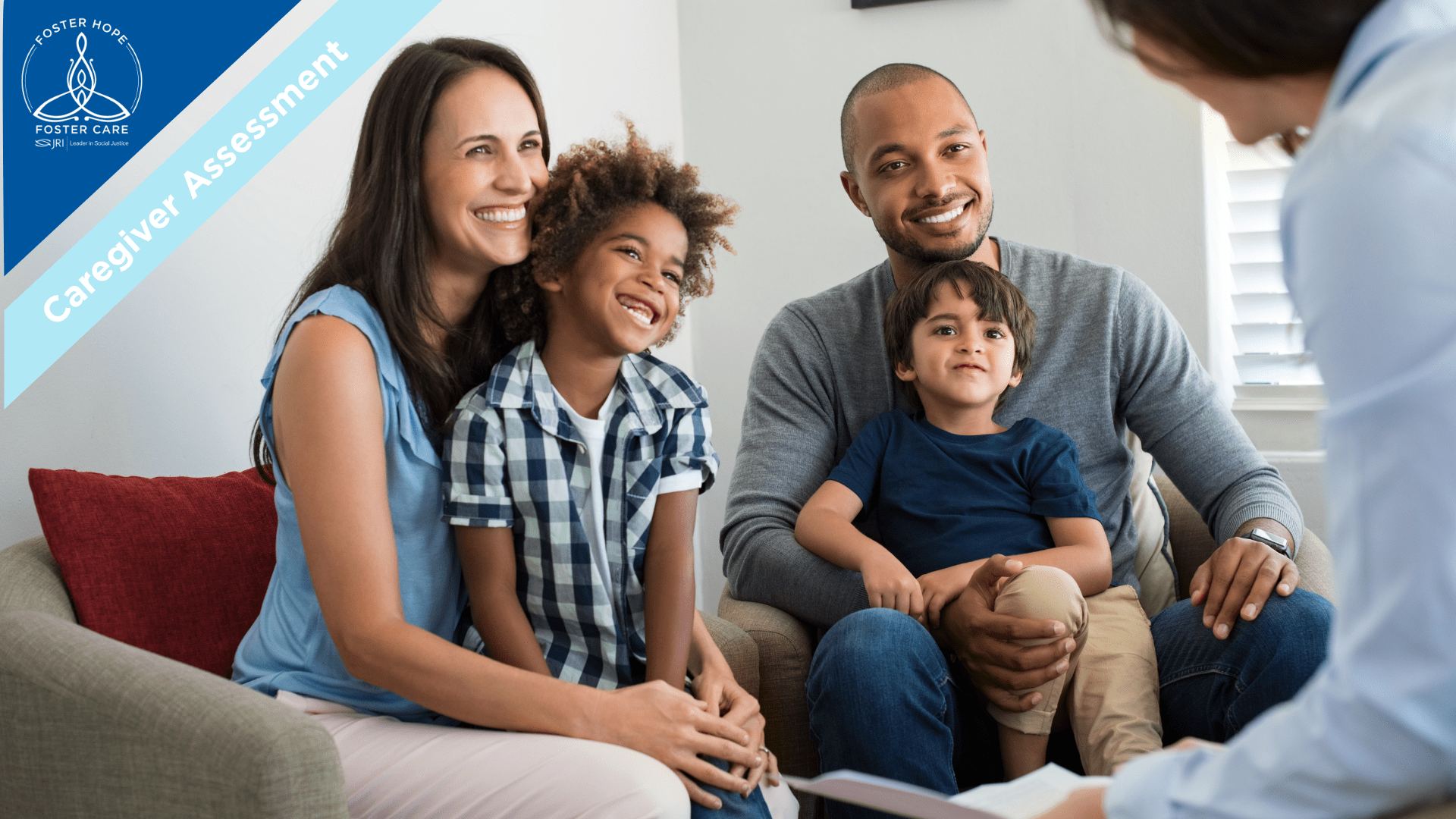 A family of four sitting on a couch during a caregiver assessment with a professional, smiling and engaging.