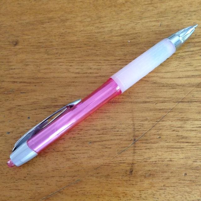 Pink and white pen on a wooden surface.