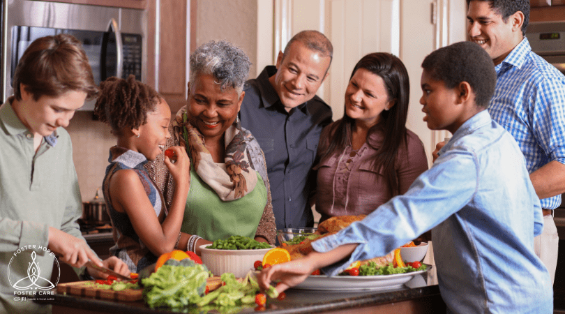 Family and friends preparing a Thanksgiving meal together in a kitchen.