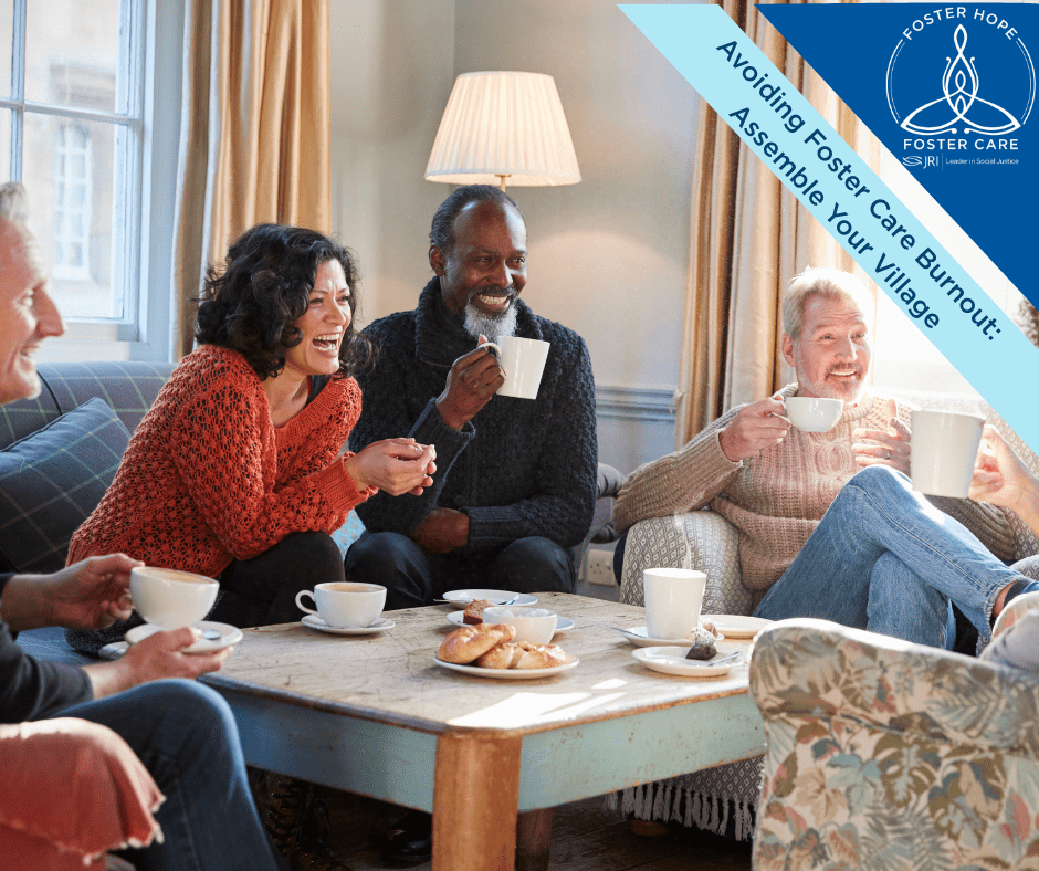 A group of people sitting on a couch enjoying tea and snacks, smiling and laughing.